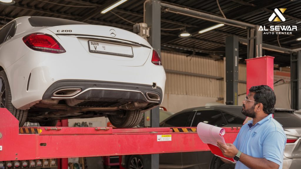 Mechanic inspecting a modern car inside a professional Dubai auto repair workshop, with diagnostic tools and equipment visible.