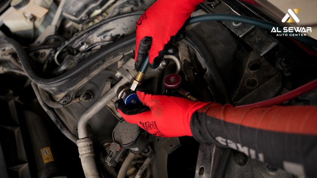 Mechanic checking car air conditioning system in Dubai workshop, ensuring proper AC maintenance for hot summer conditions.