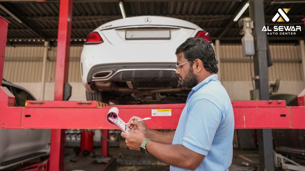 Mechanic performing routine maintenance check on a luxury car inside a professional auto repair workshop in Dubai.