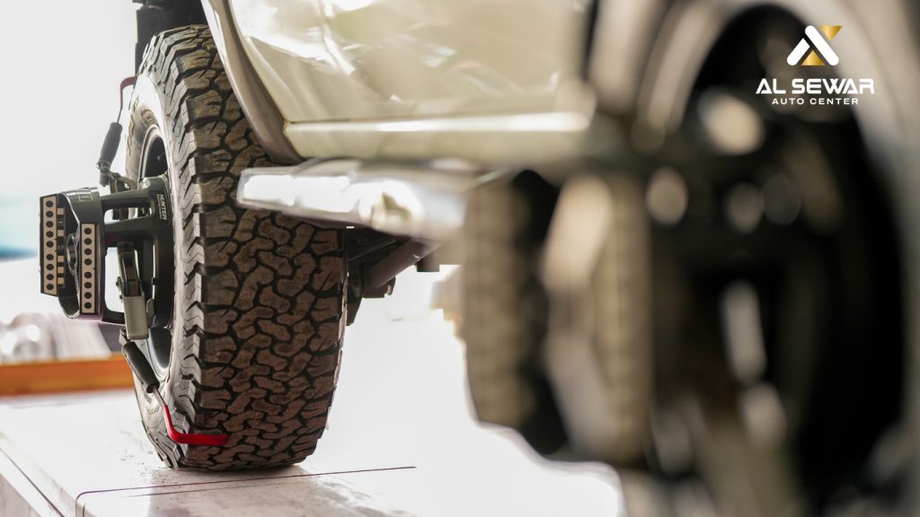 Mechanic inspecting a modern car tyre in a professional service center, highlighting tyre safety checks and proper maintenance.
