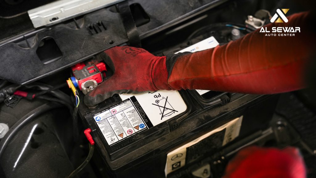 Mechanic checking car battery with diagnostic tools and battery charger, performing professional car battery service under open hood.