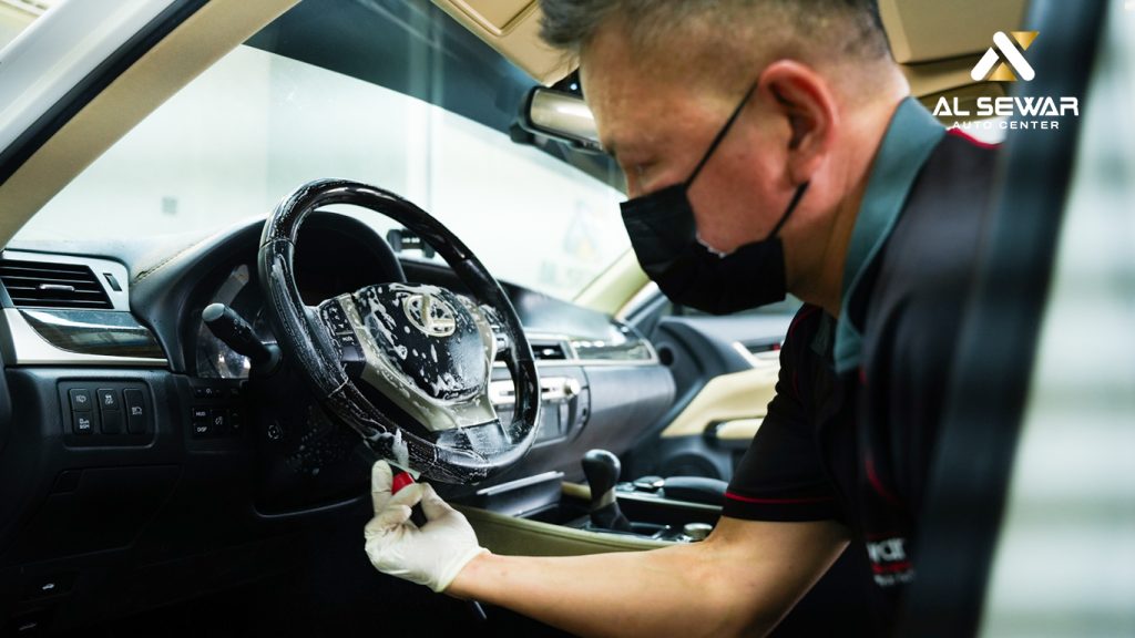 Mechanic performing professional car interior deep cleaning after UAE flood damage to remove mold and bacteria.