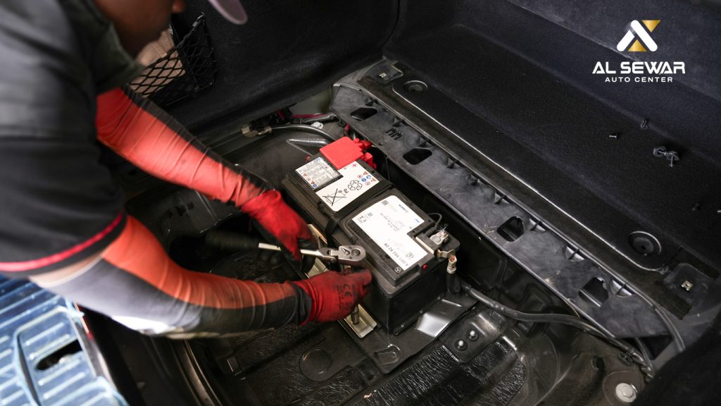 Mechanic checking car battery health to prevent summer breakdown at Alsewar Auto Dubai.