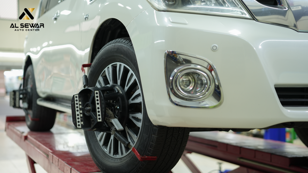 "Car undergoing professional wheel alignment service at Al Sewar Auto Center"