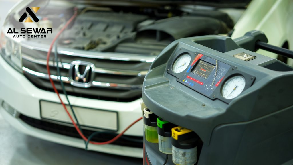 Car air conditioning system being serviced at a Dubai auto workshop with AC diagnostic equipment connected to a Honda vehicle.