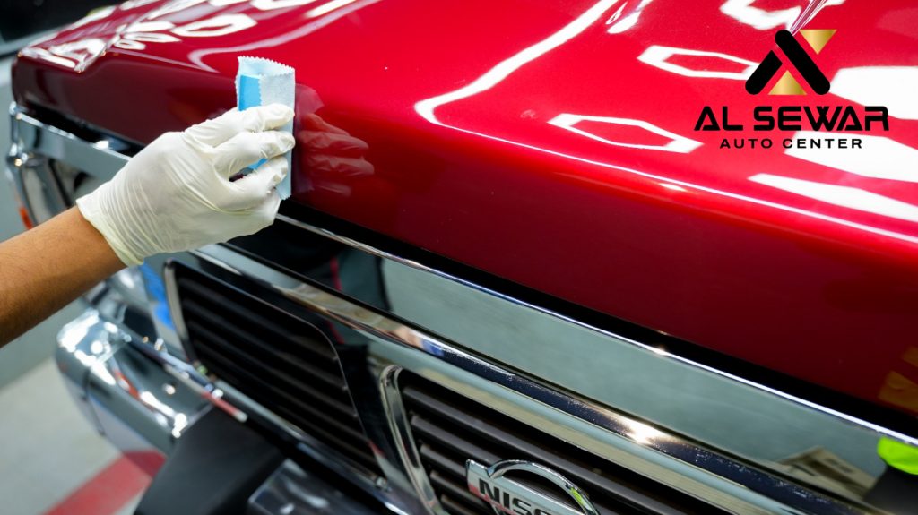 “Technician applying ceramic coating on a car’s paint surface to enhance gloss and protection.”